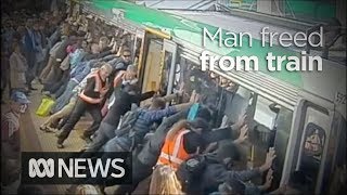 Faith in humanity restored as crowd lift train to save trapped man 2014  ABC News [upl. by Iv57]